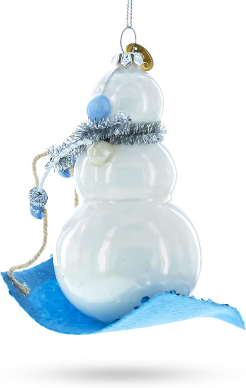 Snowman Riding a Sled Blown Glass Christmas Ornament...