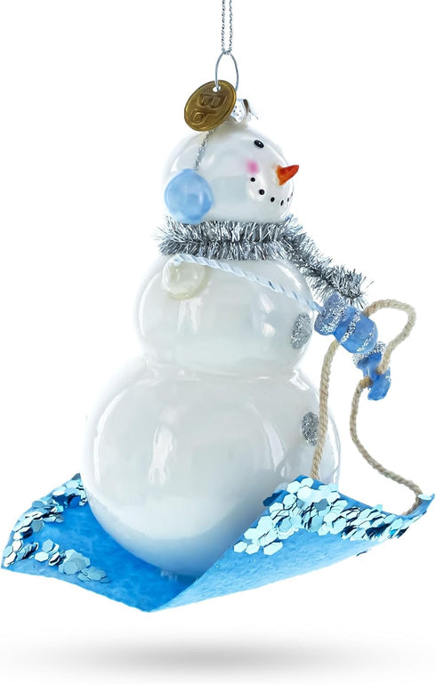 Snowman Riding a Sled Blown Glass Christmas Ornament...